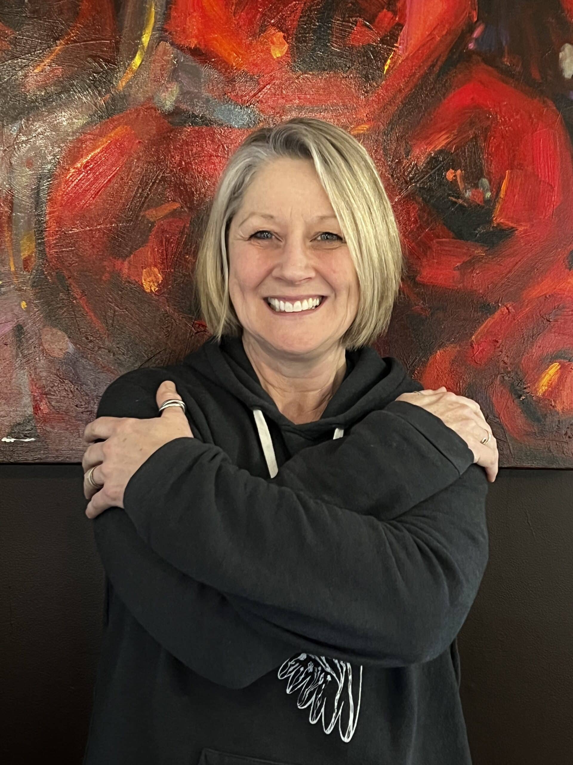 woman smiling, embracing her shoulders, taking a stand for equity